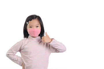 Protection Coronavirus and Air pollution pm2.5 concept. A little asian girl of 6 years old wearing a self-protect mask and show thumbs up gesture for good air and situation of Covid-19