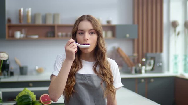 Cheerful woman enjoying food taste indoors. Young housewife smelling seafood