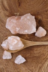 Pink Himalayan salt in a wooden spoon on a wooden board. Super food.Himalayan salt Large crystals