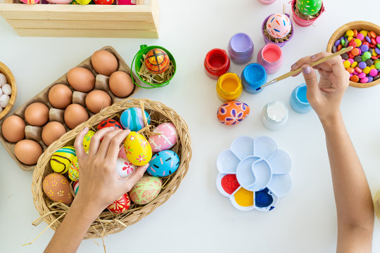 Asian young pretty woman enjoy painting a water colors on fantasy eggs for Easter egg festival.