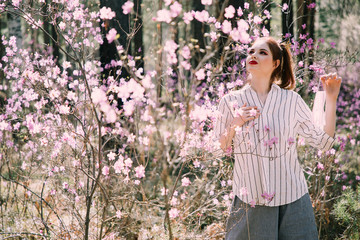 Girl in a medical mask among flowers