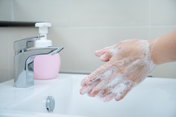 Woman washing her hands by using liquid hand washer soap for protecting from coronavirus 2019,...