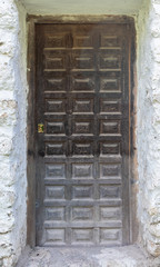 Old wooden door in a whitewashed stone wall