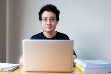 Portrait of Asian young businessman working from home during the quarantine period. Young businessman working at his home in the living room. Work from home during coronavirus disease concept.