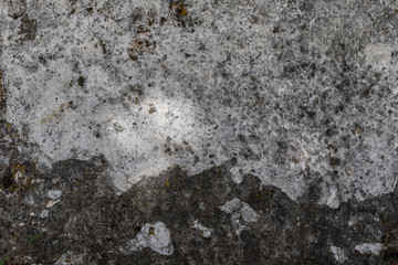 Old and deteriorated stone texture with remains of moss and vegetation