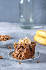Homemade banana bread with fresh bananas sliced on light background