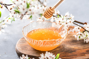 Honey and wooden spoon on background
