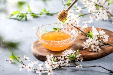 Honey and wooden spoon on background