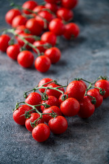 Fresh cherry tomatoes on dark background.