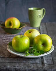 Green apples on a table covered with a green tablecloth