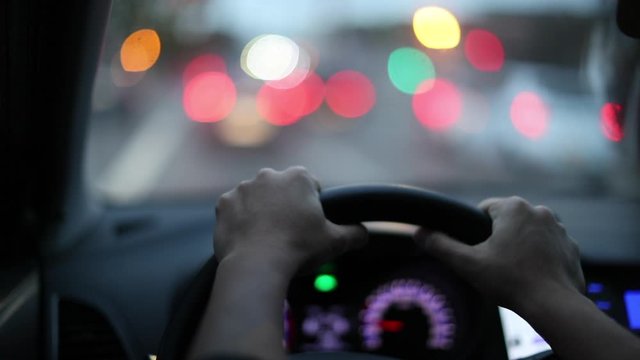 Person Holding Steering Wheel Driving In City, Point Of View POV Driver Hands