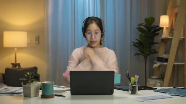 Time lapse of asian woman with multifunction skill feeling relax cacual cloth working at home, using Laptop Computer and feeling happy. Working from Home at night, self isolation in new normal concept