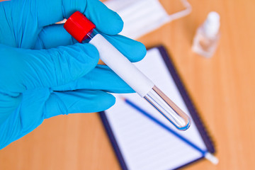 Vacuum tubes for medical work with blood samples in the laboratory. Coronavirus test. Doctor's hand in a rubber medical glove.