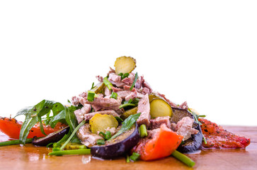 Salad with tufts of beef meat, grilled eggplant and tomatoes, arugula and egg on a wooden board, dish. The object is isolated on a white background.