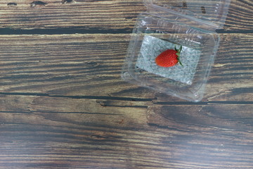 Fresh strawberries placed on a wood grain table top view .