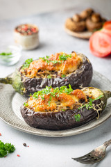 Baked aubergine or eggplant boats stuffed with mushrooms, vegetables and cheese