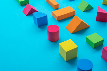 Obraz premium Set of colorful geometric cube or block toy on blue background with copy space. Abstract pattern design composition by shape and form. Education, business solution and creative design product concept.