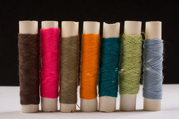 Colorful cotton yarns on rolls for sewing. Thread spools used in fabric and textile industry
