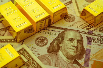 Gold bars on US dollar bill banknotes background. Concept of gold future trading, online asset...