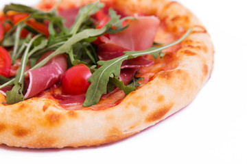 Pizza with ham, tomatoes, arugula and mushrooms on a white background.