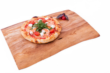 Pizza with prawns, tomatoes, arugula and cheese on a wooden tray. The object is isolated on a white background.