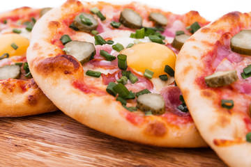 Three pizzas with ham, egg, pickled cucumber on wooden background