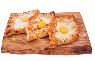 Dish of Georgian cuisine - three khachapuri on a wooden background. The object is isolated on a white background.