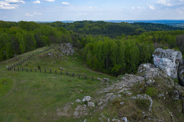 Aerial view of limestone rock formations in green located near Krakow in Poland. Shots from the drone showing the vast green hilly areas of the Cracow-Częstochowa highlands. Krak&oacute;w-Częstochowa Jura.