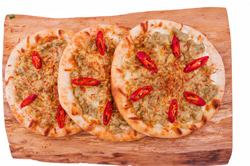 Three Pizza with curry sauce, meat, red pepper on a wooden background. The object is isolated on a white background.