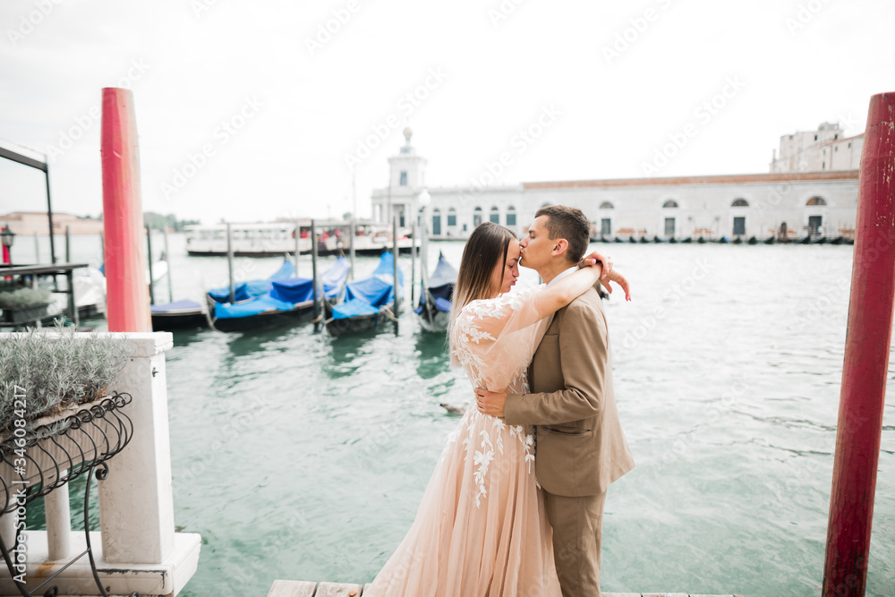 Wall mural Wedding couple on the nature is hugging each other. Beautiful model girl in white dress. Man in suit.Venice, Italy