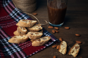 Homemade Italian cookies cantuccini on checkered napkin and glass of cocoa