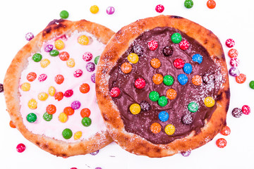 Sweet pizza with marshmallow sauce and colored sweets, chocolate pizza on a white plate