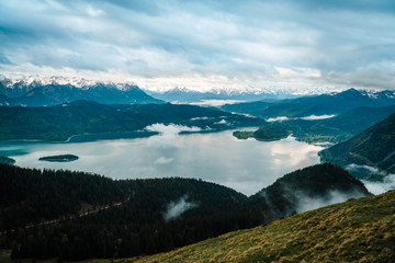 View over the mountains with clouds and fog and lake