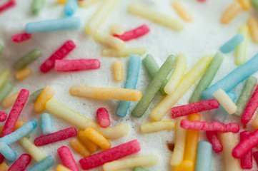 Confectionery topping in the form of sticks of pink, yellow, green and blue, close-up, macro shot.