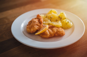 Steak with boiled potatoes on a white plate.