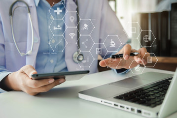 Medical Technology Concepts The doctor is working on a tablet and audio player and a digital tablet computer in a modern office  in the morning at the desk.