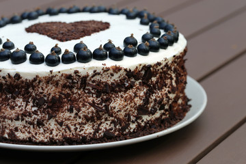 Fresh and delicious homemade summertime theme black currant, chocolate and cream cake. Topped with whipped cream, fresh berries and grated chocolate. Cheerful cake for celebrations like bday.