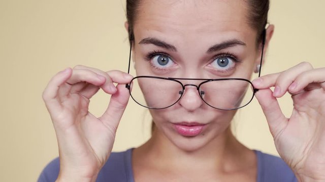 Portrait of pretty woman with glasses surprised looking at camera