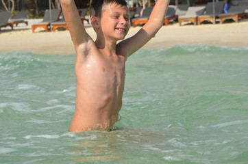 A happy caucasian child is swimming in the sea on summer vacation. A boy in a splash of water on a sunny day lifestyle © Marina Shvedak
