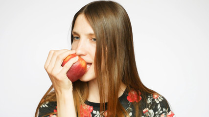 A very beautiful and happy lady catches the red apple and bites it