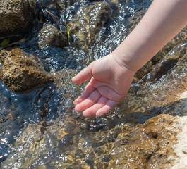 Kind wäscht Hand im Wasser
