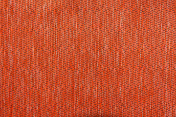 Texture of dense orange curtains. Fabric background with light lines and black stripes. Top view