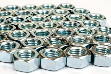 Dozens of silver nuts lined up in rows - stock photo