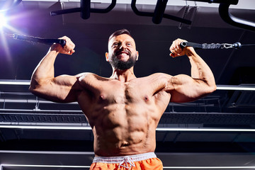 Handsome male bodybuilder in gym. Big strong man during training in the gym. Guy with big muscles...