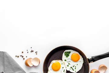 Fried eggs on frying pan on white background top view copy space