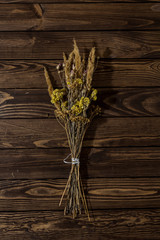 dried bouquet on the table. dry wildflowers on a wooden background. autumn still life.