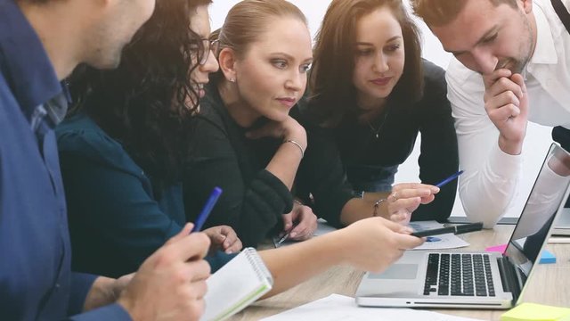 team of coworkers discussing startup project on laptop computer, group of business people working together in office,  teamwork
