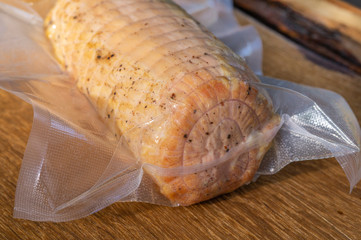 Pork ham in vacuum packaging on a wooden table