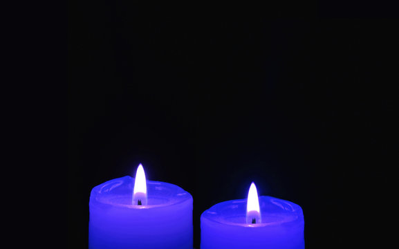 Shining Two Royal Blue Candles on Black Background with Copy Space	