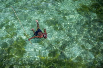 Borneo, Malaysia - 30th November, 2018 : A fisherman of the sea gypsies tribe is fishing with a...